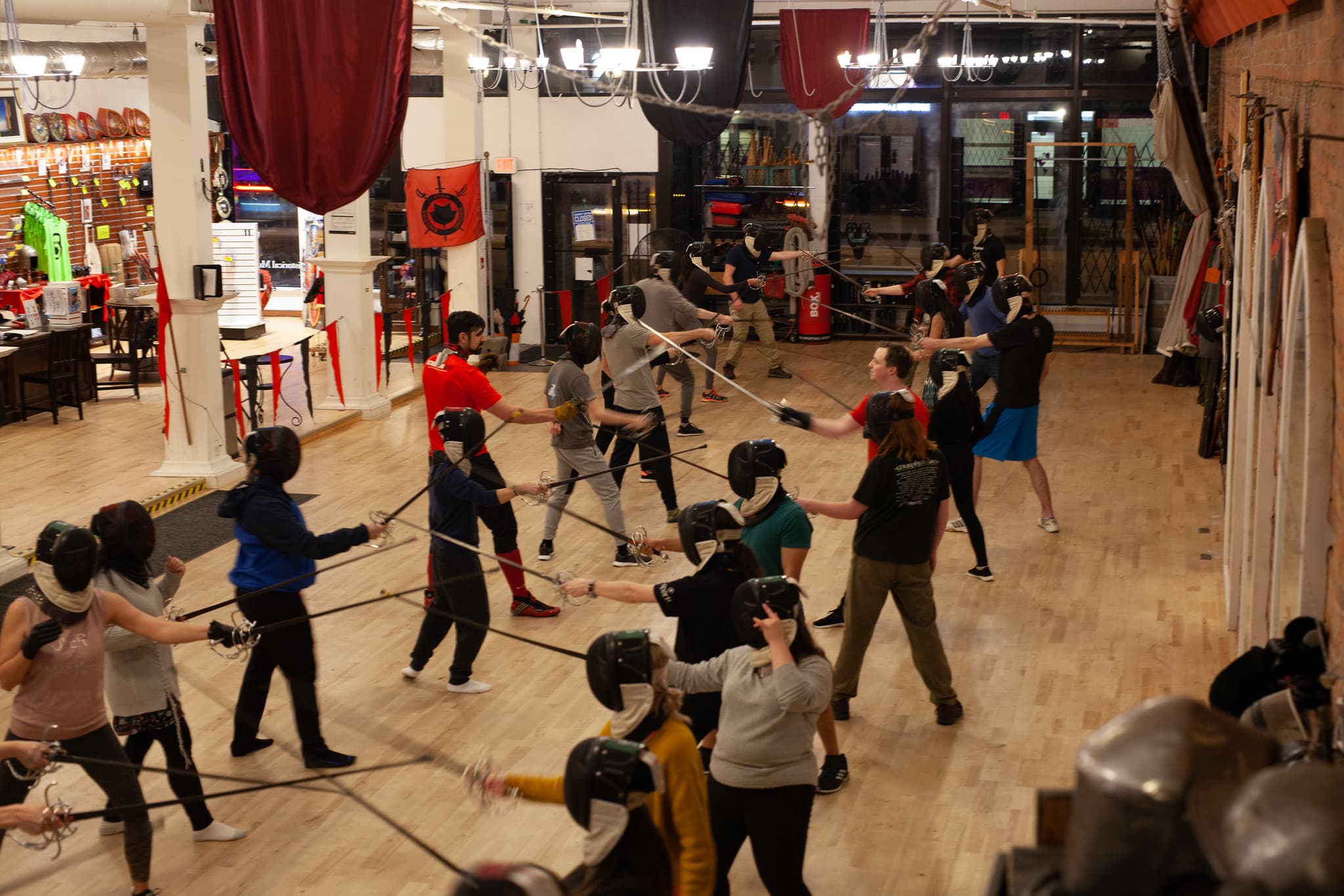 Academie Duello training hall with students practicing swordplay